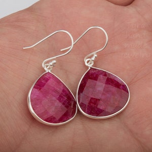 Pu&ograve; includere: Un paio di orecchini a goccia d'argento con pietre di rubino rosa sfaccettate.