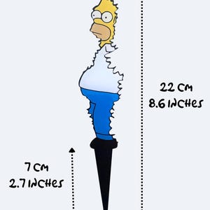 May include: Yellow cartoon character with blue jeans and a white shirt, standing on a black stake. The character is 8.6 inches tall and 2.7 inches wide.