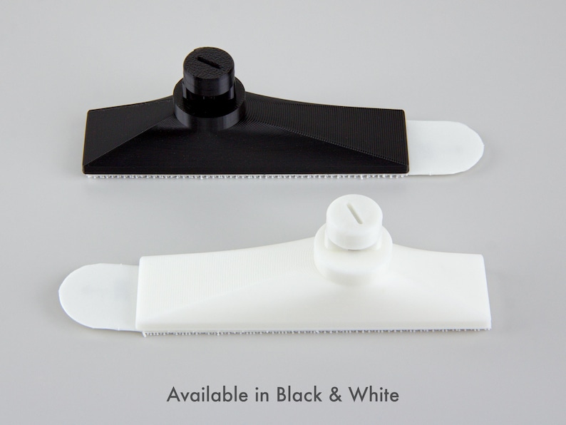 Pu&ograve; includere: Due tergivetri in plastica, uno nero e uno bianco, sono esposti su uno sfondo grigio. Ogni tergivetro ha un corpo rettangolare con un bordo strutturato e un'estremit&agrave; arrotondata. Il testo "Available in Black & White" &egrave; in basso.