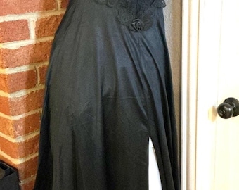 Vestido lencero vintage negro de satén con ribete de encaje y abertura, estilo oscuro y femenino de los 90, largo midi, tirantes finos.