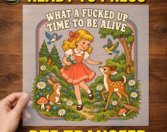 May include: A DTF transfer sheet featuring a cartoon illustration of a blonde girl in a red dress holding flowers in a forest with a fawn, a rabbit, birds, butterflies, and mushrooms. The text reads, WHAT A FUCKED UP TIME TO BE ALIVE.