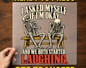 May include: A DTF transfer sheet featuring two skeletons sitting on a wooden bench. One skeleton leans back laughing, while the other covers its face. Text reads: I ASKED MYSELF IF I'M OKAY AND WE BOTH STARTED LAUGHING. The design includes a MadeForUs DTF logo.