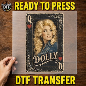 May include: A rectangular DTF transfer sheet featuring a playing card design with a portrait of a blonde woman with voluminous hair wearing a denim shirt. The card includes the letter Q, the name DOLLY, and red heart symbols on a black background.