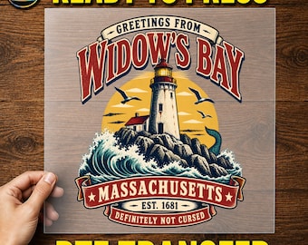 May include: A DTF transfer sheet featuring a graphic of a lighthouse on a rocky cliff with crashing waves, a yellow sun, and birds. The text reads GREETINGS FROM WIDOW'S BAY, MASSACHUSETTS, EST. 1681, and DEFINITELY NOT CURSED in red and blue lettering.