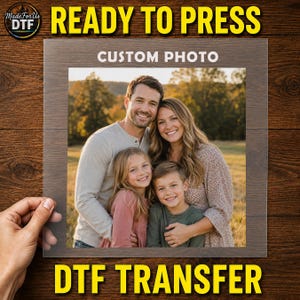 May include: A square DTF transfer sheet featuring a custom photo of a family of four, including two adults and two children, smiling outdoors. The text "CUSTOM PHOTO" is printed in white at the top centre of the transparent transfer film.