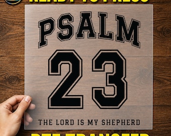 May include: A clear DTF transfer sheet featuring the black text PSALM 23 in a varsity-style font, with the number 23 prominently displayed below. The phrase THE LORD IS MY SHEPHERD is printed in a smaller, simple black font at the bottom of the sheet.