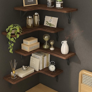 May include: A dark wood corner shelf unit with black metal brackets, displaying decorative items. The shelves hold plants, books, vases, and a small clock. A framed sign reads "Autumn Leaves, Fumekins Please."
