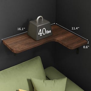 May include: A dark brown corner shelf with a wood grain finish, measuring 16.1" x 11.4" x 0.6". A gray weight with a silver handle and the text "40lbs" sits on the shelf. The shelf is mounted on a dark wall.