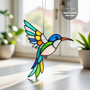 May include: A stained glass hummingbird suncatcher with a vibrant color palette of blue, green, yellow, orange, and white. The bird is suspended by a thin wire, with a black outline. The image includes the text "Favedite Studio" and "Digital Download Hobby License".