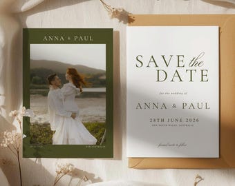 May include: A wedding save the date card set featuring a dark olive green photo card with a couple and a white card with the text SAVE THE DATE for the wedding of ANNA & PAUL 28TH JUNE 2026, tucked into a tan envelope on a white fabric background.