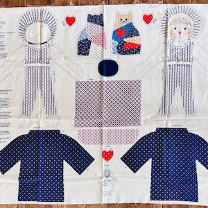 Può includere: Un modello di tessuto bianco con istruzioni per realizzare una bambola chiamata "Lizzie Beth & Meow". Il modello include un vestito, una salopette e un gatto. Il modello è stampato in rosso, blu e bianco.