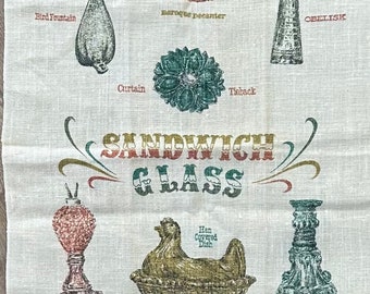 Puede incluir: Una toalla de cocina vintage con una ilustración colorida de varios objetos de vidrio. El texto "SANDWICH GLASS" está impreso en una fuente audaz y colorida. Los objetos incluyen una fuente para pájaros, una jarra barroca, un obelisco, una cortina, un amarre, una lámpara de clavos, un plato cubierto de gallina y un candelabro.