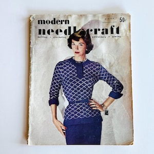 May include: A vintage "Modern Needlecraft" magazine cover showing a woman in a blue diamond-patterned sweater and skirt. The magazine has the text "Winter" and "Seventeenth Issue". The magazine is slightly worn.