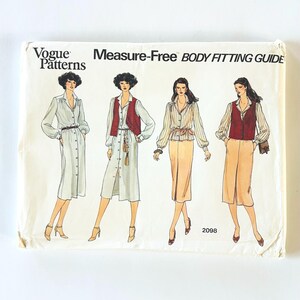 May include: A Vogue Patterns Measure-Free Body Fitting Guide sewing pattern envelope 2098. The front features illustrations of four outfits including button-down shirts, skirts, dresses, and vests in shades of white, tan, and dark red.