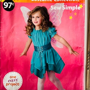 Op de afbeelding: Een jong meisje in een turquoise feeënkostuum met een gelaagde rok, een veterriem en doorschijnende mouwen. Het kostuum bevat roze feeënvleugels. De achtergrond is een roze poster met de tekst "Sew Simple" en "One Easy Project."