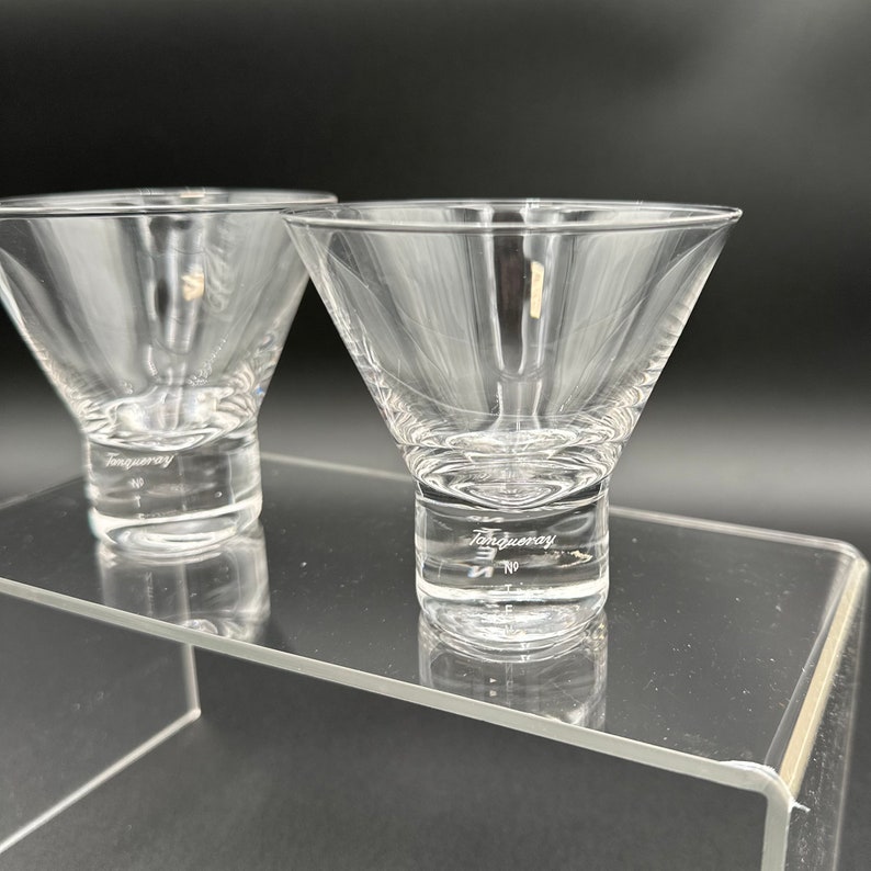 Peut inclure: Deux verres &agrave; martini en verre transparent avec un pied &eacute;pais. Le verre de droite a le mot "Tanqueray" grav&eacute; dans le pied.