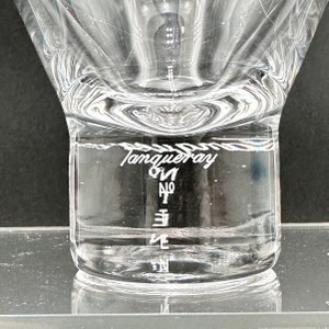 Peut inclure: Une bouteille en verre transparente &agrave; large ouverture et &agrave; surface textur&eacute;e. La bouteille est remplie d'un liquide clair et porte l'inscription "Tanqueray Gin No. Ten" grav&eacute;e sur le c&ocirc;t&eacute;.