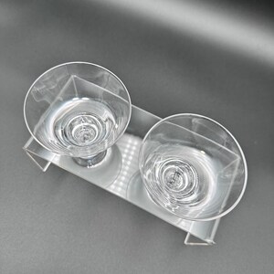 Peut inclure: Deux verres &agrave; boire en verre transparent avec un motif en spirale sur un support en acrylique transparent.