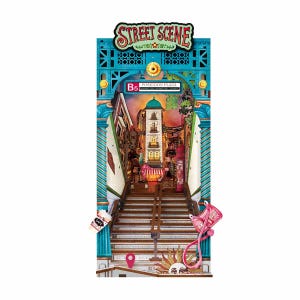 Può includere: Un kit diorama 3D intitolato STREET SCENE che mostra una scala che conduce a un edificio etichettato POSEIDON PLAZA B5. La struttura include archi architettonici color ottanio, un sole, una borsa rosa e un bicchiere con la scritta CAFE.