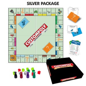May include: A custom board game set titled CUSTOMPOLY featuring a square game board with light green centre, a black storage box, stacks of orange and blue cards, property cards, two white dice, and several small plastic houses and player tokens.