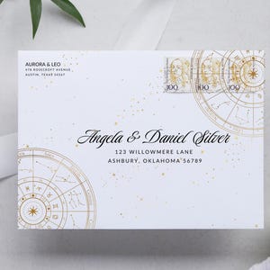 May include: White envelope with gold astrological designs and the names "Angela & Daniel Silver." Includes address and postage stamps. The envelope also has the return address "AURORA & LEO" and their address.