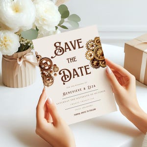 May include: A cream-colored "Save the Date" card with brown text and steampunk-style gear accents. The card reads "Save the Date" and includes wedding details for Genevieve & Leza, October 16, 2026, in Tulsa, Oklahoma.