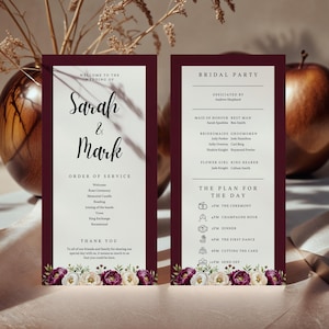 May include: Wedding ceremony programs with burgundy borders and floral accents. The programs list the order of service, bridal party, and schedule. The names "Sarah & Mark" are featured in elegant script.