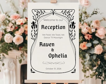 May include: A cream-colored wedding reception sign on a wooden easel. The sign features black text that reads "Welcome to our Reception" and the names "Raven & Ophelia" with the date "October 31, 2026". The sign is decorated with floral accents.