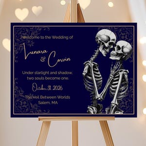 May include: A navy blue wedding sign on an easel, featuring the text "Welcome to the Wedding of Lunara & Corvin." The sign includes a graphic of two skeletons embracing. The date "October 31, 2026" is also displayed.