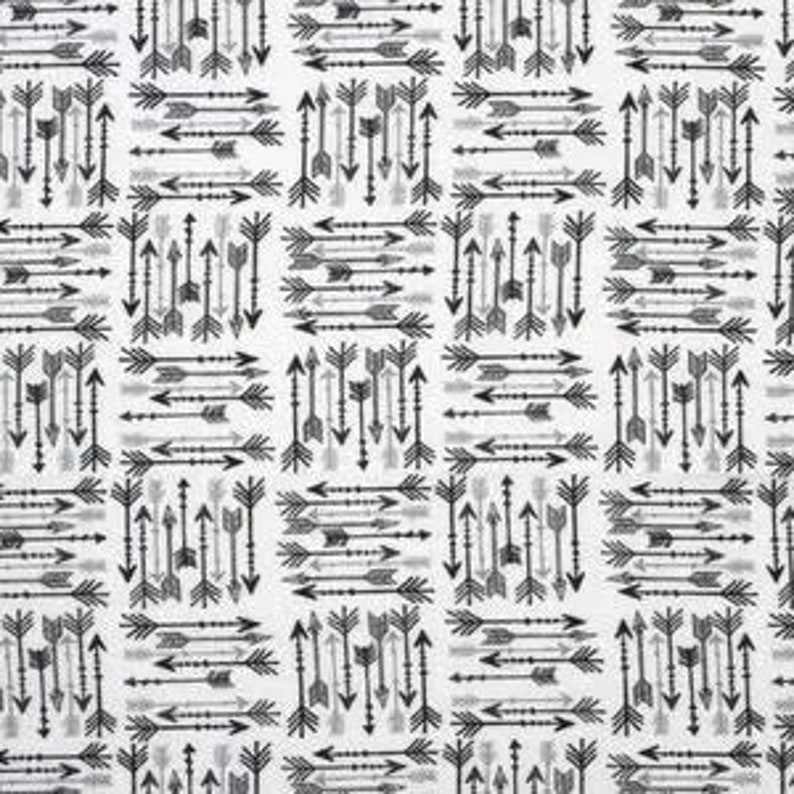 May include: A white fabric featuring a repeating pattern of black and gray arrows arranged in alternating horizontal and vertical blocks. Each block contains a cluster of arrows pointing in various directions, creating a geometric grid design.