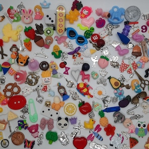 May include: A large collection of colorful charms and pendants, including animals, food, flowers, and other whimsical designs. The charms are made of various materials, such as metal, plastic, and glass.