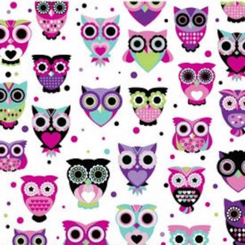May include: A white fabric pattern featuring a repeating design of stylized owls in various shades of pink, purple, teal, and black. The owls are decorated with geometric shapes, hearts, and circles, interspersed with small black and purple polka dots.