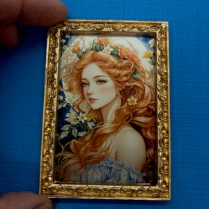 May include: A framed illustration of a woman with long, flowing red hair wearing a floral crown. The background is a blue and green watercolour wash with white flowers.