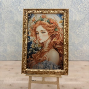 May include: A framed painting of a woman with long red hair wearing a flower crown. The painting is set on a wooden easel against a blue and white patterned background.