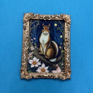 May include: A framed illustration of a squirrel sitting on a branch in a forest setting. The squirrel is brown and white with a bushy tail. The background is a dark blue with pink flowers and glowing lights.