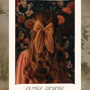 Puede incluir: Un lazo de ganchillo color mostaza en el pelo de una persona, sobre un fondo floral. Tambi&eacute;n se ve el texto "Crochet Pattern Antelope" y "Eloise Grande". El lazo es el foco de la imagen.