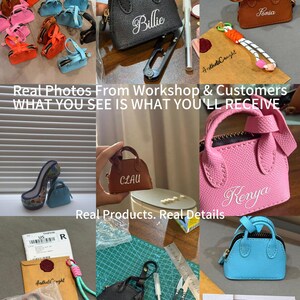May include: A collection of miniature handbag keychains in various colors including black, pink, brown, and blue. Each bag features a zipper closure, two top handles, and custom white embroidered names like Billie, Sonia, Clau, and Kenya.