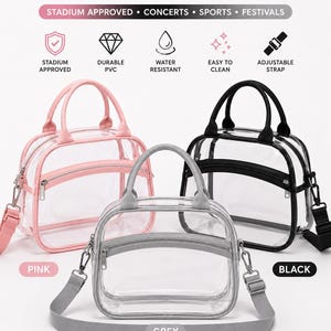 May include: Three clear PVC stadium bags in pink, grey, and black. Each bag features a top handle, a front zippered pocket, and an adjustable shoulder strap. Text includes CLEAR STADIUM BAG, STADIUM APPROVED, CONCERTS, SPORTS, FESTIVALS, DURABLE PVC, WATER RESISTANT, EASY TO CLEAN, ADJUSTABLE STRAP, PHONE, SUNGLASSES, LIPSTICK, WALLET, KEYS, PERFUME, and EARBUDS.