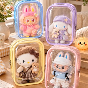 May include: Four rectangular clear vinyl pouches with colored zippers and piping, each containing a plush character doll. The pouches are blue, purple, yellow, and pink, housing dolls dressed in various outfits including hats and accessories.