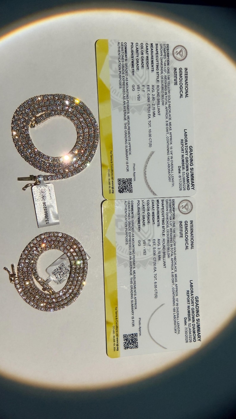 May include: Two 14k yellow gold necklaces with round brilliant laboratory grown diamonds, accompanied by two International Gemological Institute grading summary cards. The cards detail specifications including 10.00 and 8.05 total carat weights.