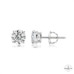 a pair of diamond earrings, one earring on the left and one earring on the right, both made of silver and showcasing a large, clear gemstone.