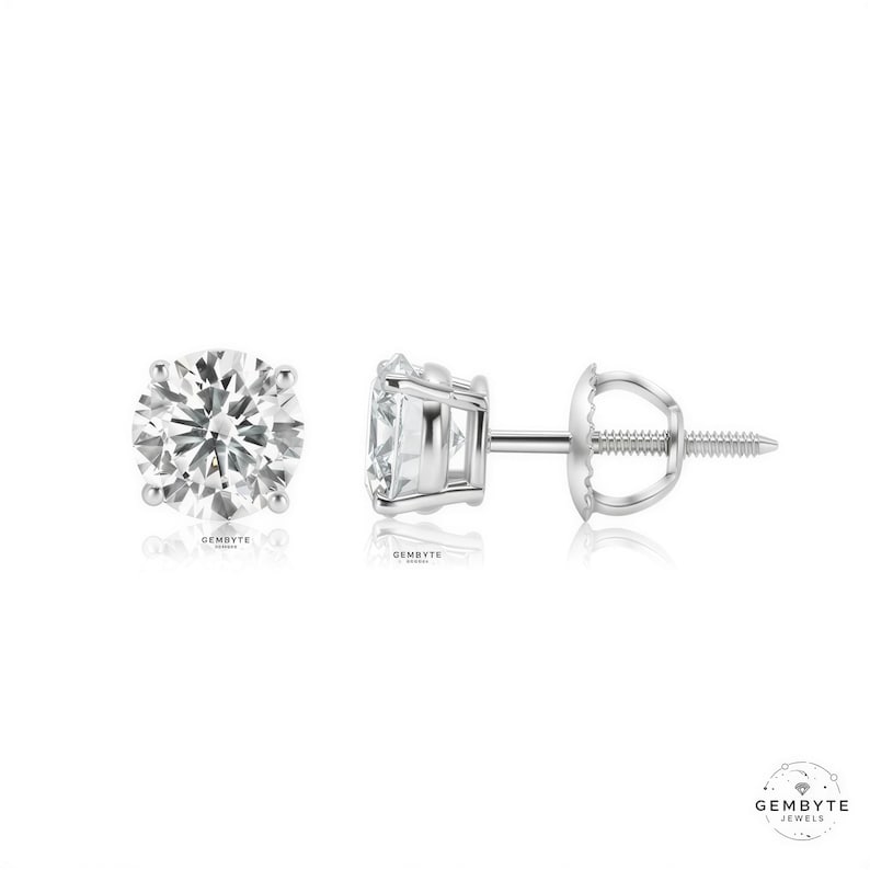 a pair of diamond earrings, one earring on the left and one earring on the right, both made of silver and showcasing a large, clear gemstone.