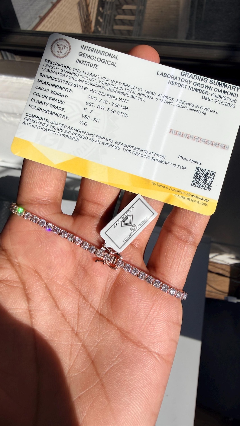 May include: A 14 karat pink gold tennis bracelet featuring round brilliant laboratory grown diamonds, accompanied by an International Gemological Institute grading summary card stating a length of 7 inches and a total weight of 5.00 carats.