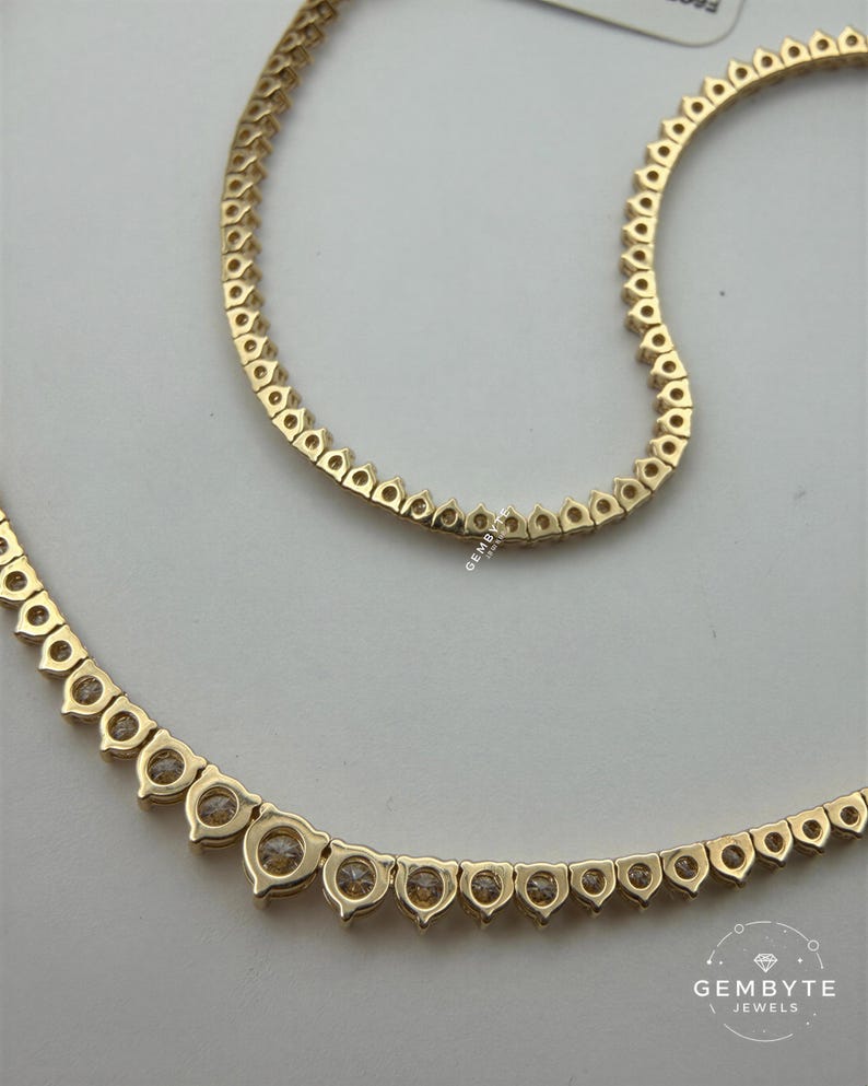 a gold necklace with a row of small diamonds or gemstones set in the center.