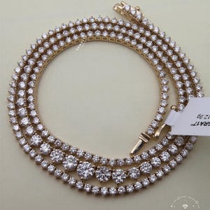A gold necklace with numerous large diamonds arranged in a circular pattern.
