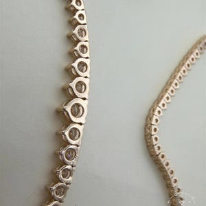 a close-up view of a gold-colored necklace with a row of small circular pendants.