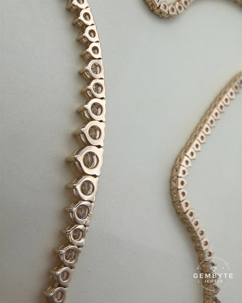 a close-up view of a gold-colored necklace with a row of small circular pendants.