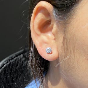 A close-up view of a person's ear adorned with a diamond earring.