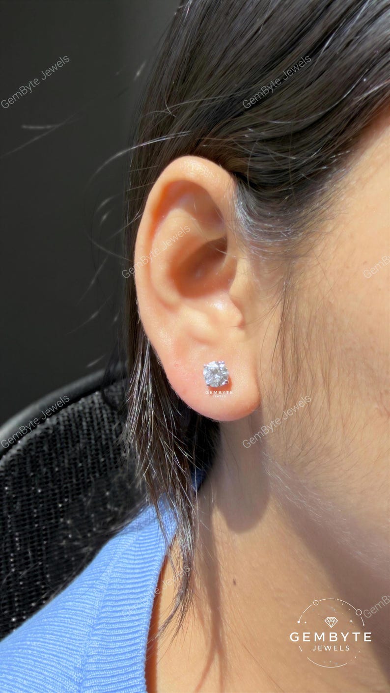 A close-up view of a person's ear adorned with a diamond earring.