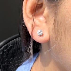 A close-up view of a person's ear adorned with a diamond earring.